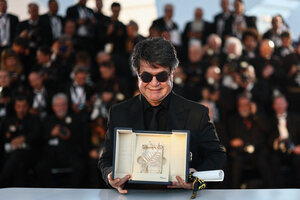 Der Regisseur Jafar Panahi mit Sonenbrille und schwarzem Anzug streckt dem Publikum die 