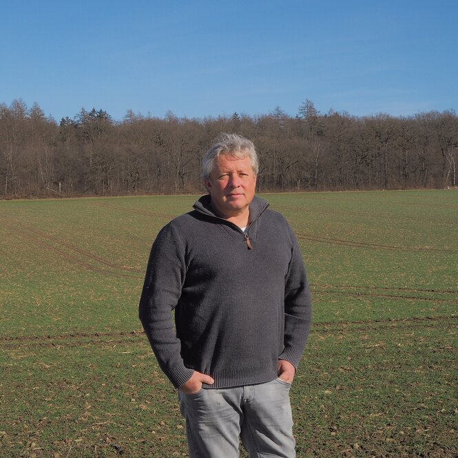 Ein Mann steht auf einer Wiese