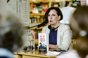 Klementyna Suchanow sitzt am Rednerpult, vor ihr ihr Buch 