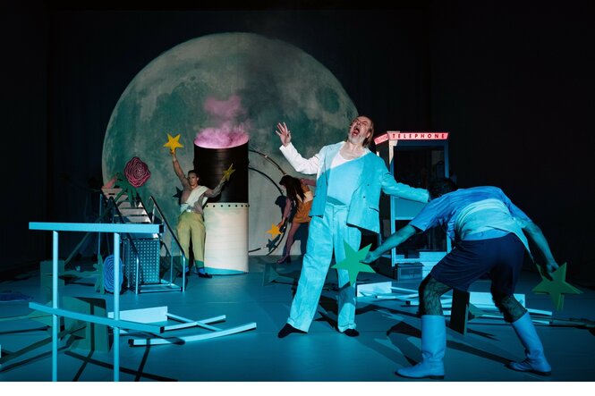 Schreiende und mit Sternen spielende Personen auf einer Theaterbühne