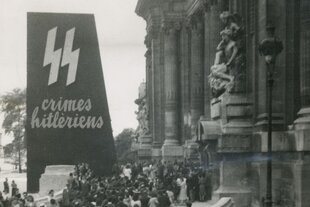 Großes Gedränge in der Nachkriegszeit vor einem Gebäude, in dem NS-Verbrechen ausgestellt werden
