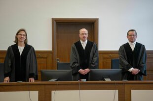 Zwei Richter und eine Richterin bei der Urteilsverkündung im Meta-Prozess