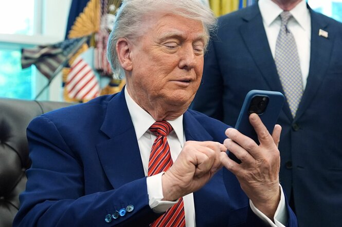 Trump schaut auf sein Smartphone