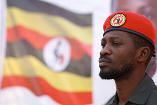 Bobi Wine vor der Flagge Ugandas, auf seinem Barett ein Emblem mit dem Spruch: People Power – Our Power
