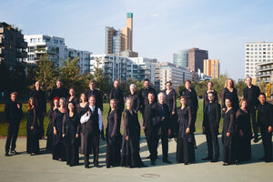 Die Mitglieder des Rias Kammerchor stehen in einem Park. Hinter ihnen ist eine Skyline zu sehen.