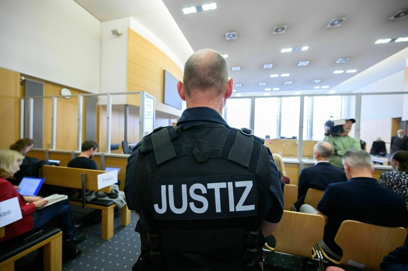 Ein Justizbeamter, von hinten zu sehen, steht im Gerichtssaal im Landgericht Braunschweig
