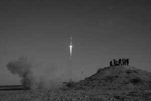 Zu sehen ist eine Rakete beim Start. Rechts im Bild eine Gruppe Menschen die den Start beobachten.