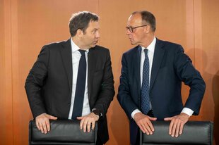 Zwei Männer im Anzug Lars Klingbeil und Friedrich Merz stehen nebeneinander und sprechen mit einander