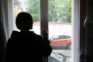 Eine Jugendliche blickt aus einem Fenster