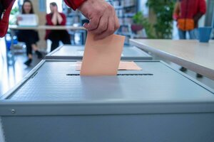 Ein Wähler steckt seinen Wahlschein in die Urne