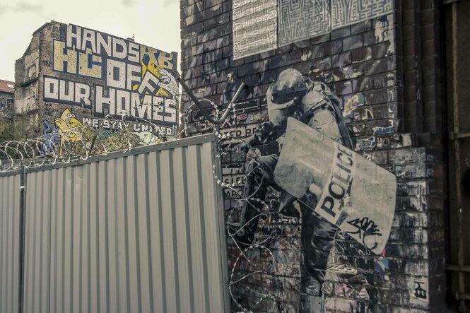 Die Wagenburg Köpi in der Köpenicker Straße nach der Räumung durch die Polizei am 15.10.2021. Auf einem Wandgraffiti ist zu lesen: "Hands off our homes. We stay united".