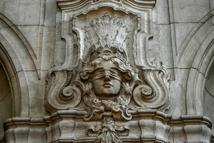 Ein Relief mit der Abbildung der Justitia, der römischen Göttin der Gerechtigkeit und des Rechtswesens, mit verbundenen Augen und einem allsehenden Auge über der Stirn