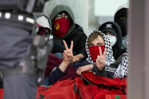 Vermummte Personen mit Pali-Tuch machen das Victory-Zeichen