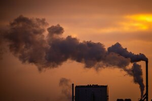 Rauch steigt aus Schornsteinen von holzverarbeitenden Industriebetrieben auf