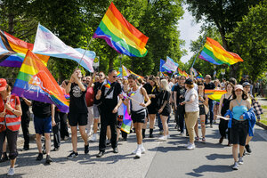 Menschen mit Regenbogenfahnen bei einer Demonstration.