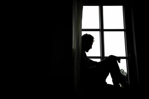 Eine Person sitzt vor einem Fenster