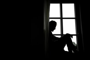 Eine Person sitzt vor einem Fenster