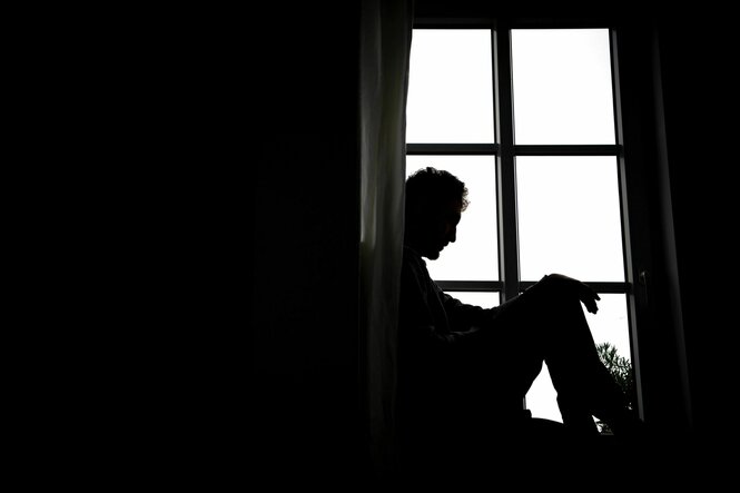 Eine Person sitzt vor einem Fenster