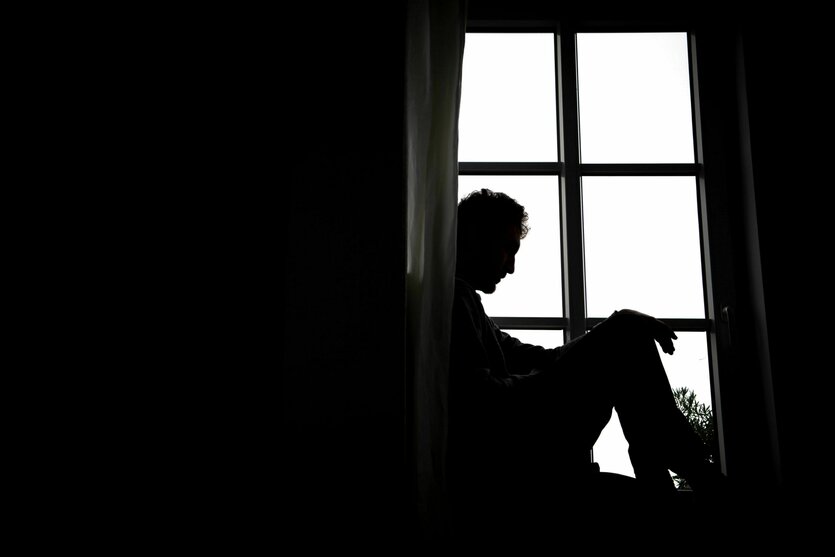 Eine Person sitzt vor einem Fenster