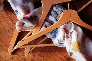 Hölzerne Kleiderbügel und ein Tuch mit Blumenmuster