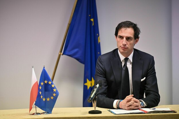 Ein mann sitzt an einem Tisch, auf dem ein Europafähnchen steht