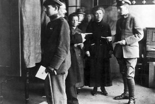 Historische SChwarz-weiß-Aufnahmevon Wählern und Wählerinnen in einem Wahllokal
