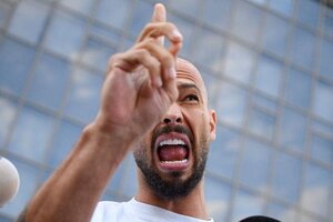 Andrew Tate spricht und macht eine Handbewegung