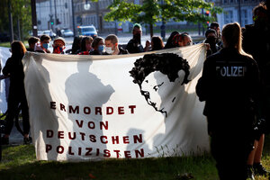 Menschen halten ein Transparent mit dem Bild von Oury Jalloh während einer Demonstration gegen Polizeibrutalität und Rassenungleichheit nach dem Tod von George Floyd im Polizeigewahrsam von Minneapolis in Dessau, Deutschland, 11. Juni 2020