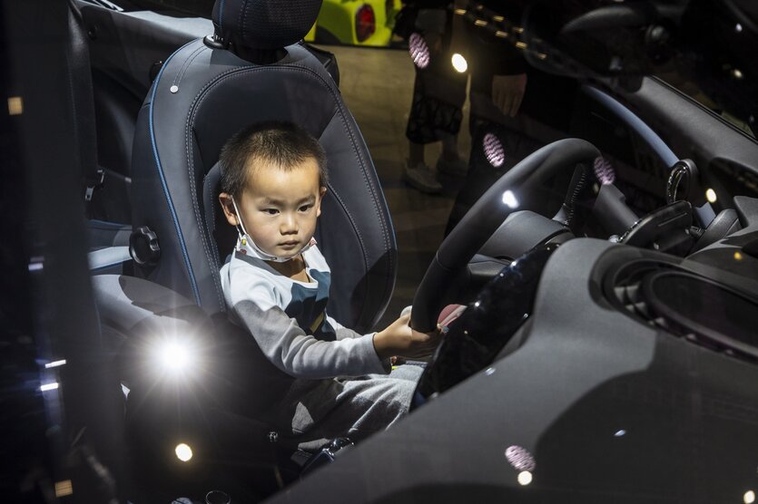 Ein kleiner Junge sitzt hinter dem Lenkrad eines Autos