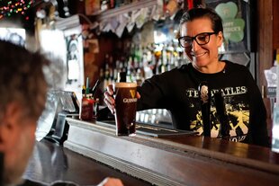 Wirt reicht Bier über den Tresen