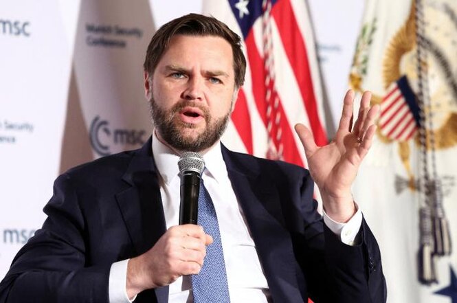 US-Vizepräsident J.D. Vance hält in seiner rechten Hand ein Mikrofon und gestikuliert mit der linken Hand