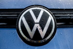 Volkswagen-Logo an einem blauen Auto im Regen.