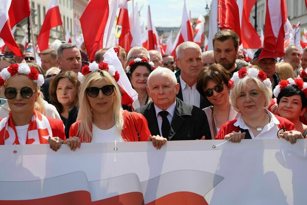 Während einer Demonstration schwenken Menschen rot-weiße Flaggen