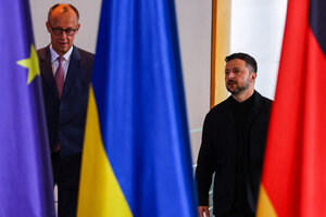 Kanzler Merz und Präsident Selenskyj zwischen Flaggen.