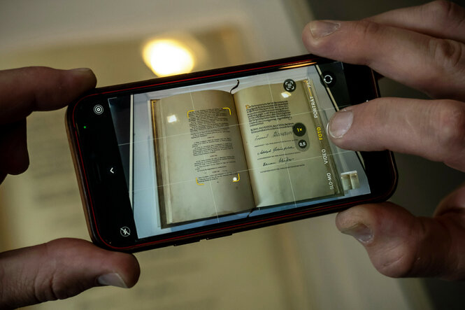 Ein Besucher fotografiert in der Bibliothek des Bundestags die Urschrift des Grundgesetzes