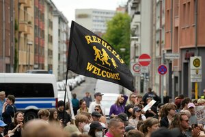 Menschen protestieren mit einer schwarz-gelben Fahne auf 