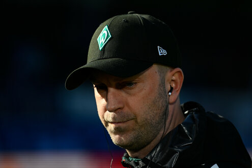 Porträtansicht eines mannes mit Werder-Bremen-Kappe, das Gesicht großteils im Schatten: Fußball: Bremens Damals-noch-Trainer Ole Werner, Ende März in Kiel