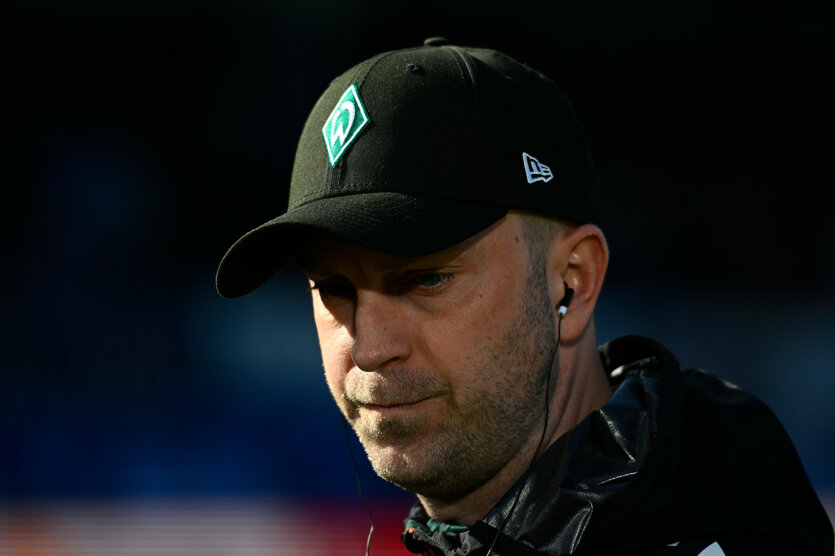Porträtansicht eines mannes mit Werder-Bremen-Kappe, das Gesicht großteils im Schatten: Fußball: Bremens Damals-noch-Trainer Ole Werner, Ende März in Kiel