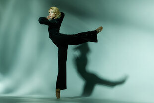 Man sieht eine Ballett-Tänzerin, die als Marlene Dietrich in einem schwarzen Kostüm tanzt.