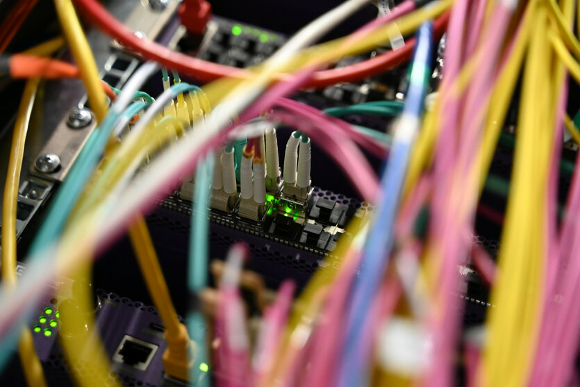 Netzwerkkabel stecken in den Rechnern eines Rechenzentrums.