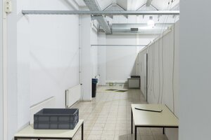 Tische in einem Flur, Kabel hängen von der Decke
