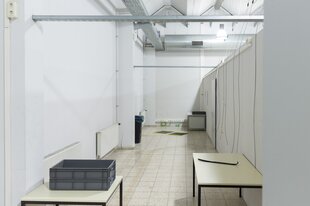 Tische in einem Flur, Kabel hängen von der Decke