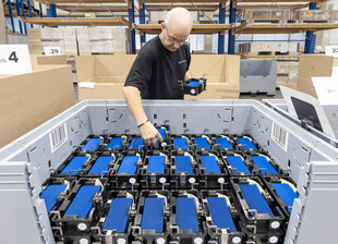 Ein Mann räumt Solarzellen in eine Kiste