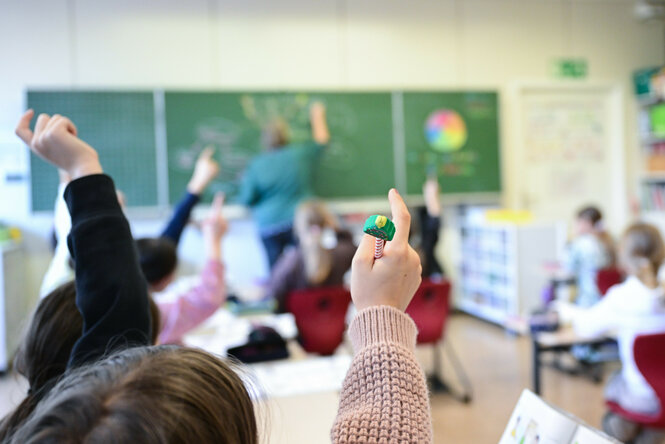 Schüler melden sich in einer vierten Klasse in einer Grundschule