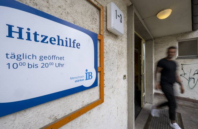 Eine Tafel mit Informationen zu den Öffnungszeiten hängt am Eingang zu der Notunterkunft der Hitzehilfe für wohnungs- und obdachlose Menschen im Bezirk Schöneberg. Die erste Sommer-Notunterkunft Berlins wird in Zusammenarbeit mit Internationalem Bund (IB) betrieben und bietet Platz für 30 obdach- oder wohnungslose Menschen gleichzeitig.