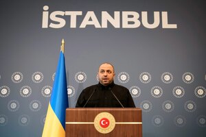 Rustem Umjerow an einem Pult, hinter ihm der Schrftzug 