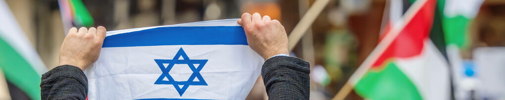 Israel-Flagge vor Palästina-Flagge im Hintergrund