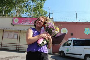 Die Journalistin Elif Akgül steht kurz nach ihrer Freilassung mit einem Blumenstrauss vor dem Gefängnis