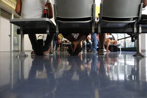Menschen sitzen auf Stühlen und warten, Kamera in Fußhöhe