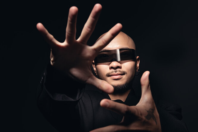 Porträt des Musikers Dzung mit Sonnenbrille und nah vor der Kamera gehaltenen Händen